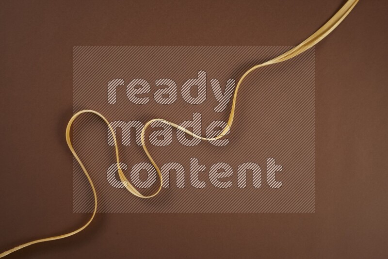 A yellow collection of sewing and tailoring tools arranged on a brown background