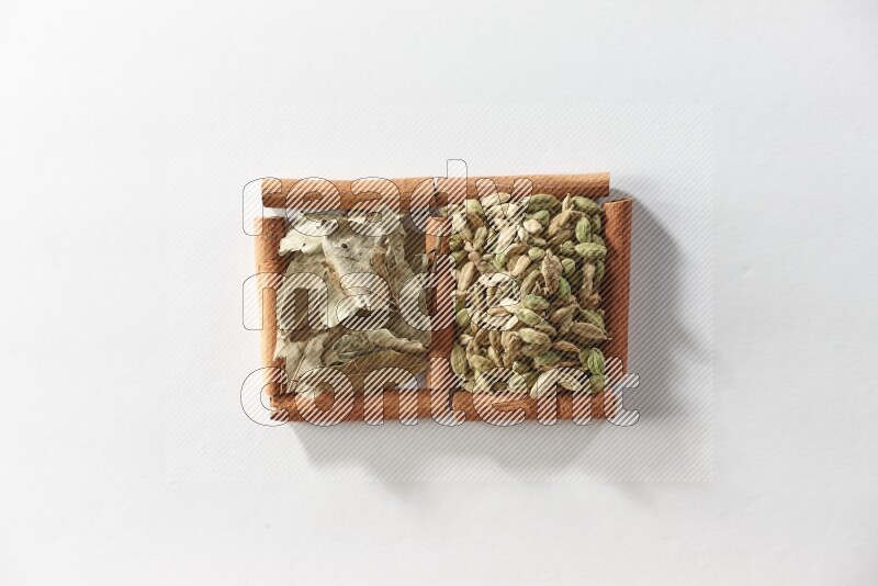 2 squares of cinnamon sticks full of cardamom and bay laurel leaves on white flooring