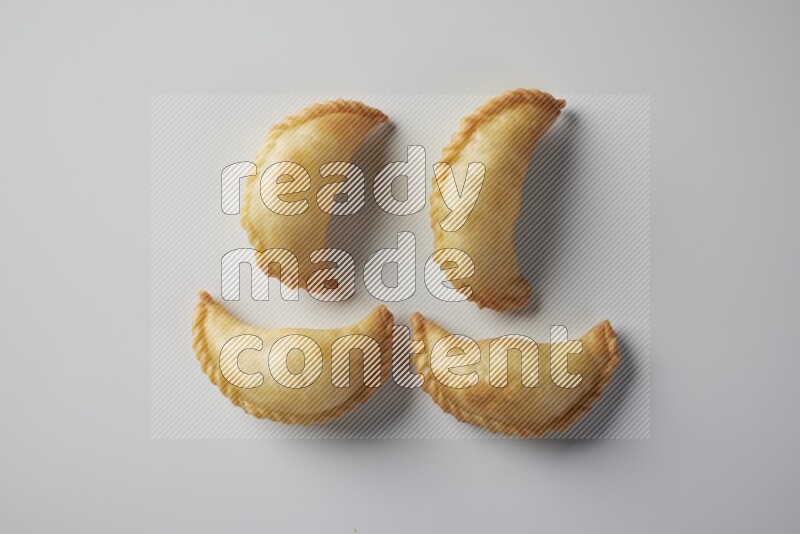 Four fried sambosa from a top angle on a white background