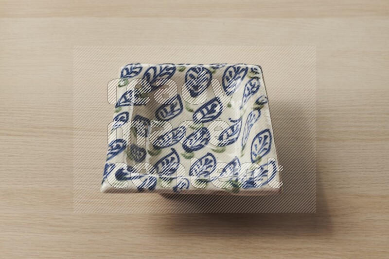 A decorative pottery plate on light wooden background