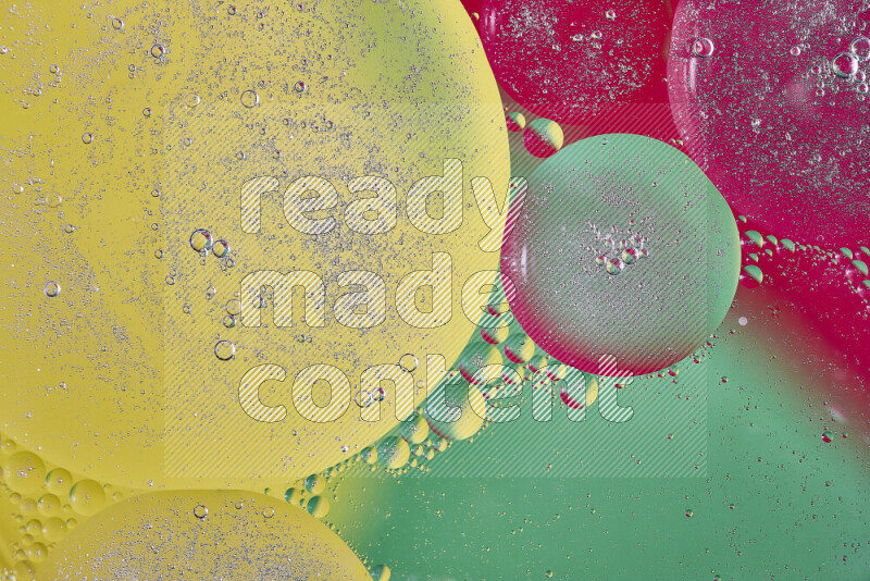 Close-ups of abstract oil bubbles on water surface in shades of yellow, green and red