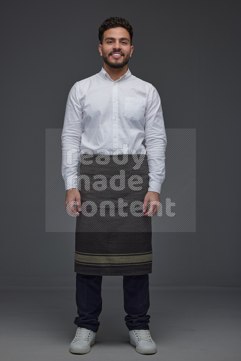 A man wearing smart casual and apron standing and making multi poses eye level on a gray background