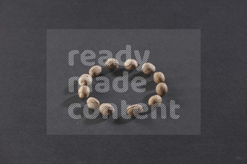 Nutmeg in a circle shape on a black flooring in different angles