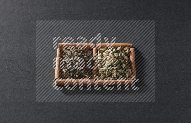 2 squares of cinnamon sticks full of cardamom and dried basil on black flooring