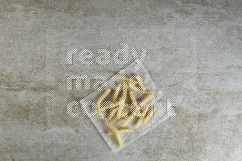 crinkle fries on parchment paper on grey textured counter top