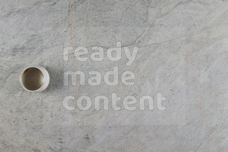 A multicolored pottery Cup on grey marble background