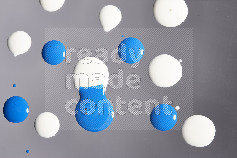 Close-ups of abstract white and blue paint droplets on the surface