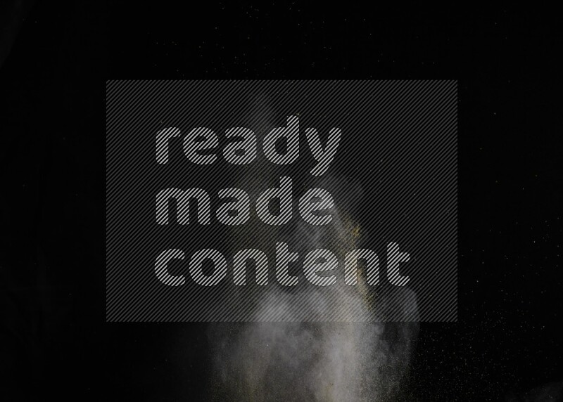A side view of brown powder explosion on black background