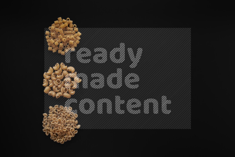 Different pasta types in 3 bunches on black background