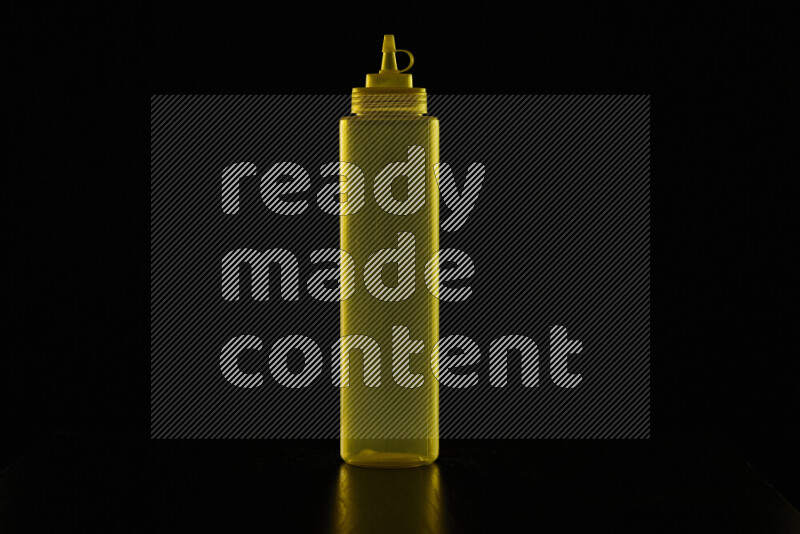 A squeeze bottle with colored rim light against black background