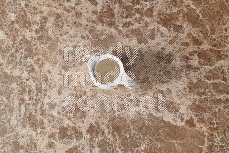 A ceramic milk jug on beige marble background