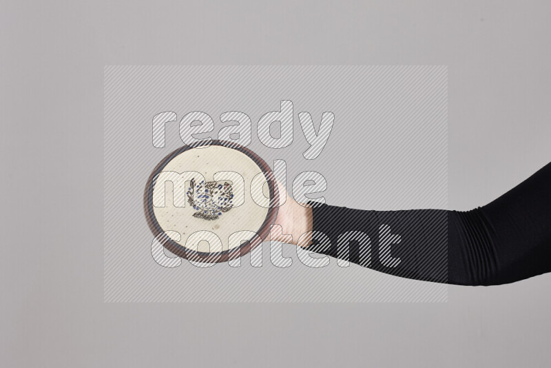 A woman in black abaya holding different pottery essentials in different positions