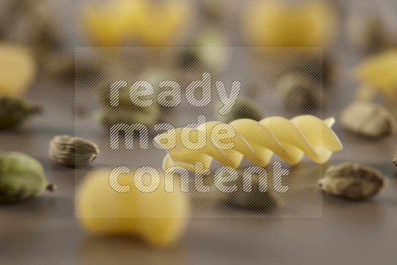 معكرونة مع مكونات متنوعة من الطماطم والثوم والبصل والفلفل الأحمر والفلفل الأسود والفلفل الأبيض وأوراق الغار وإكليل الجبل والهيل على خلفية بيج