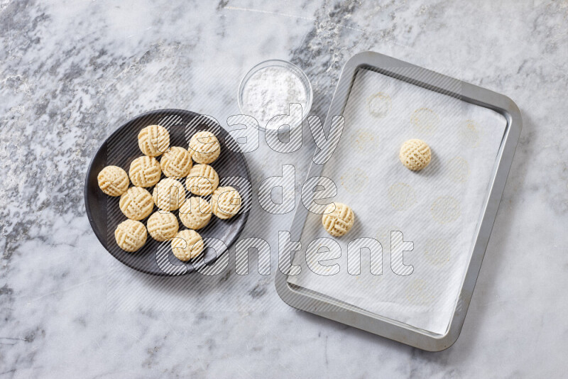 كحك خطوة بخطوة بمكوناته سمن، سكر، دقيق، سمسم، خميرة، ماء ونكهة الكحك على خلفية رخام رمادي