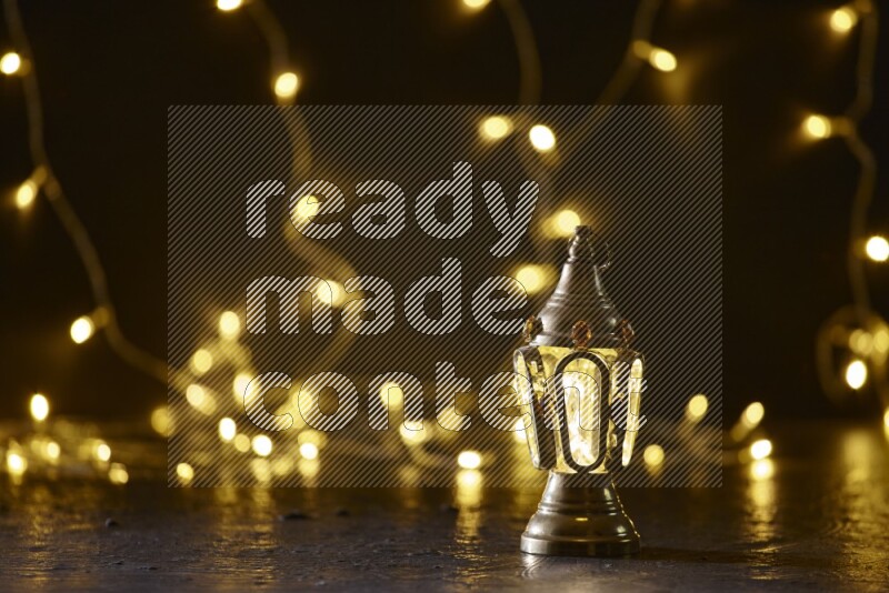 A traditional ramadan lantern surrounded by glowing fairy lights in a dark setup
