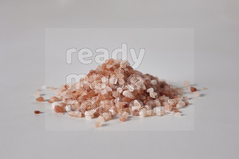 A bunch of coarse himalayan salt crystals on white background