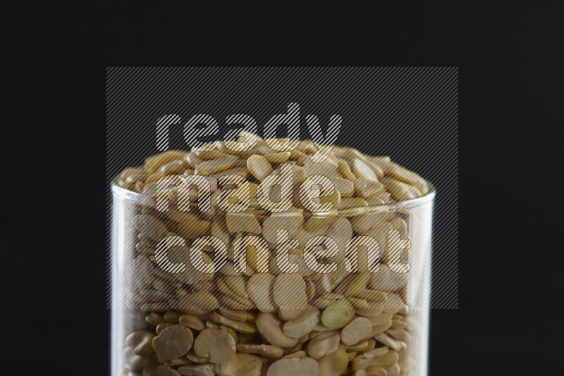Crushed beans in a glass jar on black background