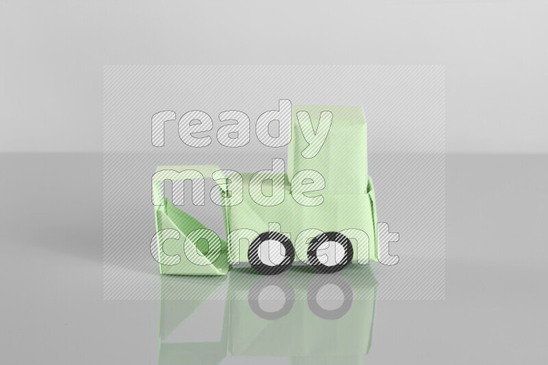 Origami bulldozer on grey background
