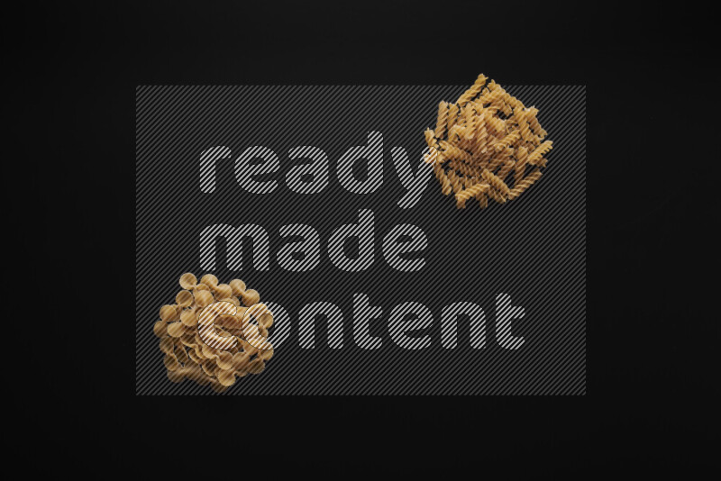 Different pasta types in bunches on black background