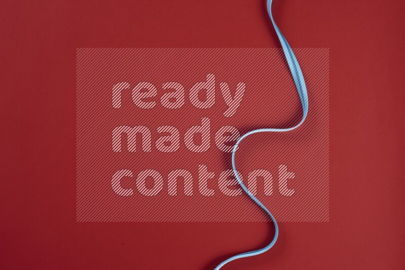 A blue and red collection of sewing and tailoring tools arranged on a red background