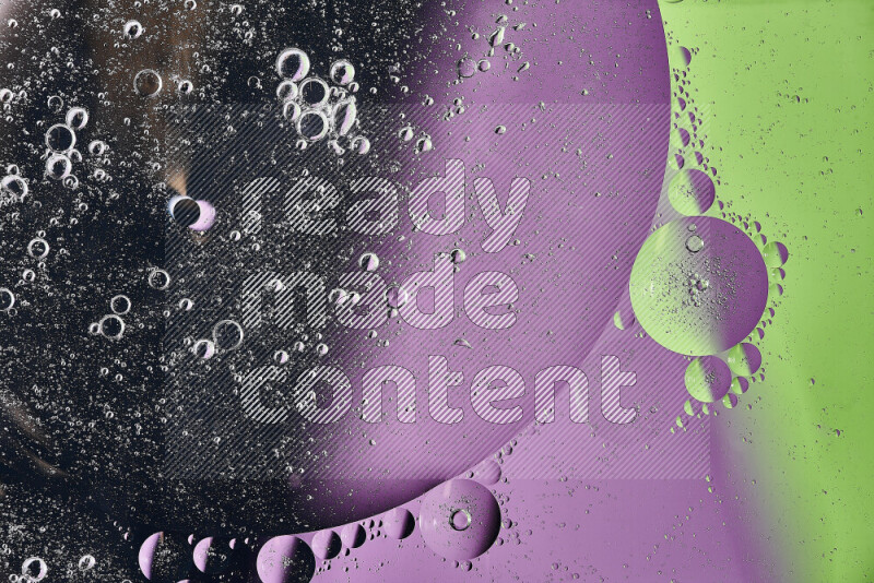 Close-ups of abstract oil bubbles on water surface in shades of black, green and purple