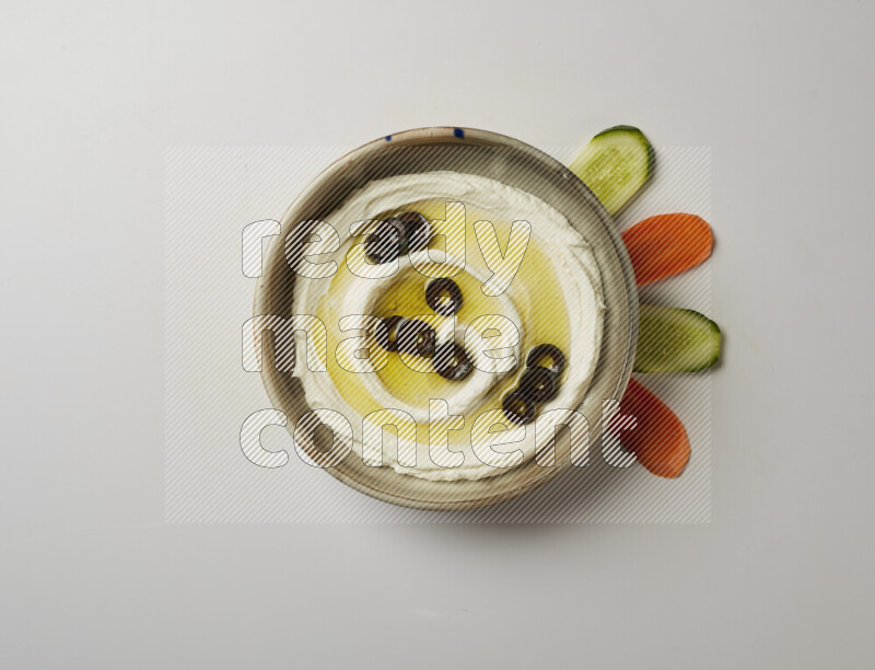 Lebnah garnished with sliced olives in a grey pottery plate on a white background