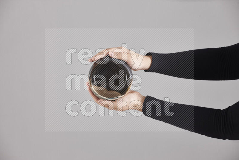 A woman in black abaya holding different pottery essentials in different positions