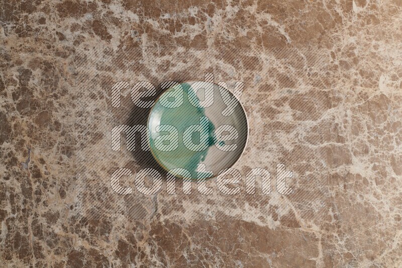 A decorative pottery plate on beige marble background