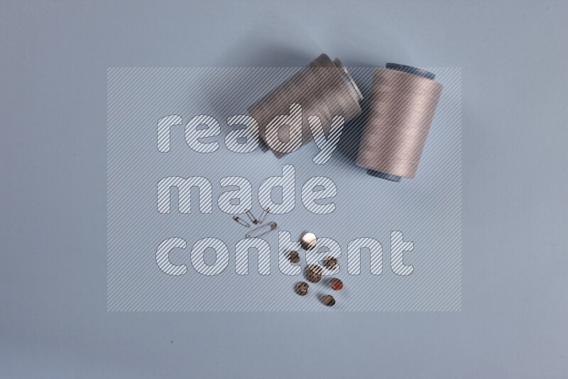 A grey collection of sewing and tailoring tools arranged on a blue background