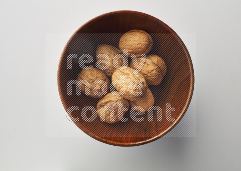 Top-view shot of walnut in a container on white background