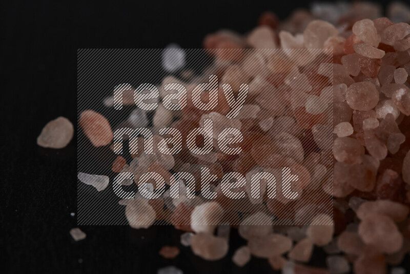 A bunch of coarse himalayan salt crystals on black background