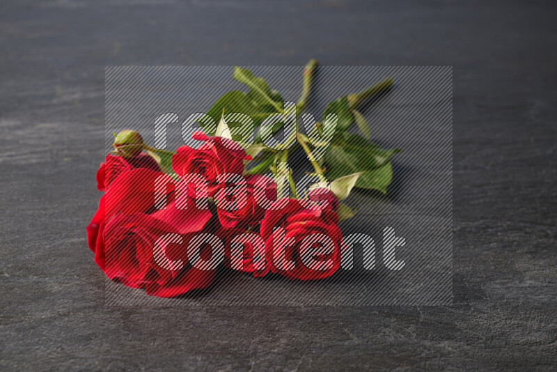 Red roses in different sizes on black marble background