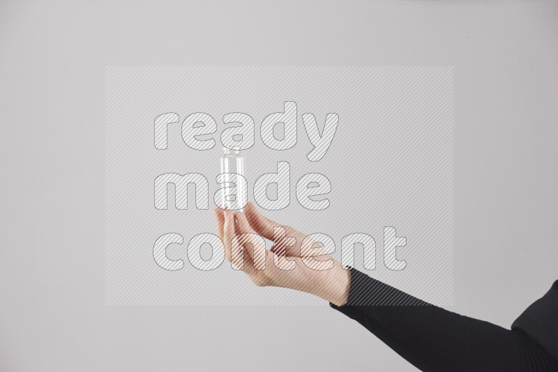 A woman in black abaya holding different glassware in different positions