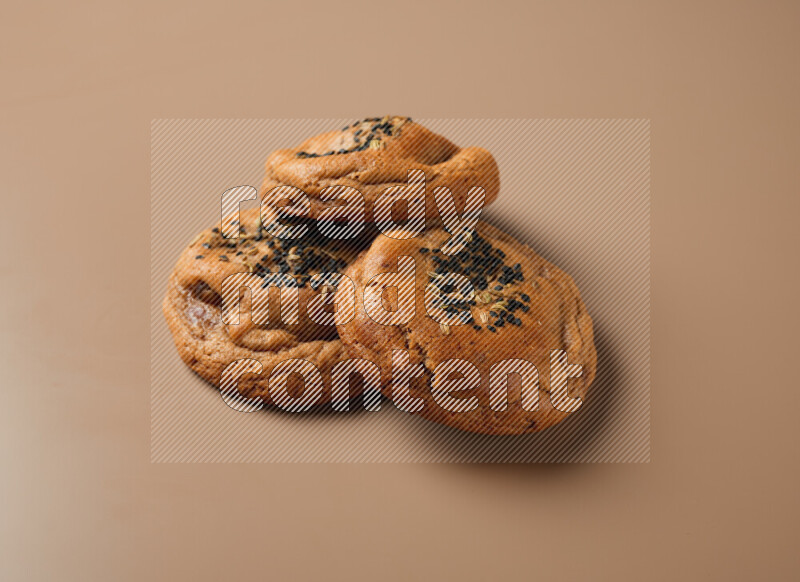 Hasawi cookies field with date and decorated by black seed and Anise grain on a brown background