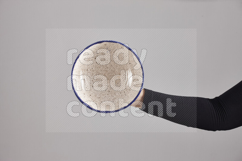 امرأة ترتدي عباءة سوداء تحمل أدوات فخارية مختلفة في أوضاع متعددة