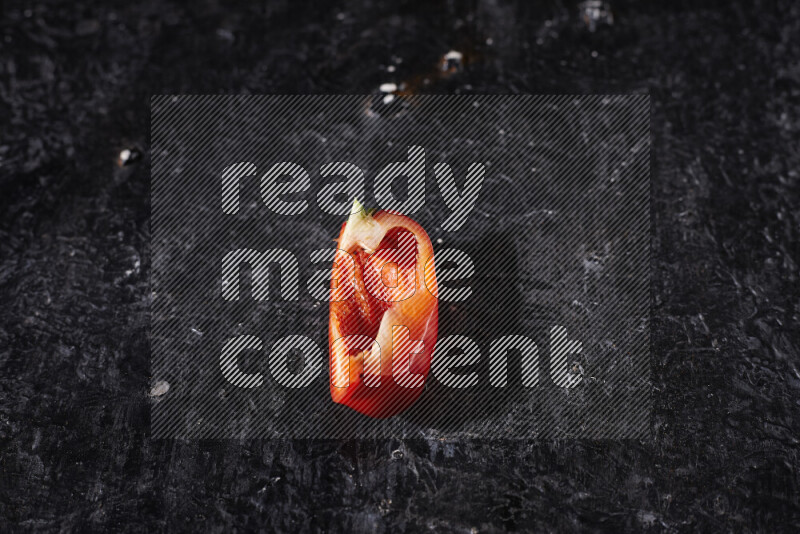 Red bell pepper slices on black background