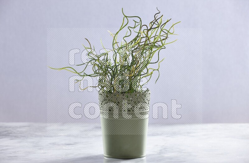 Artificial plant in green decorative pot on grey marble background