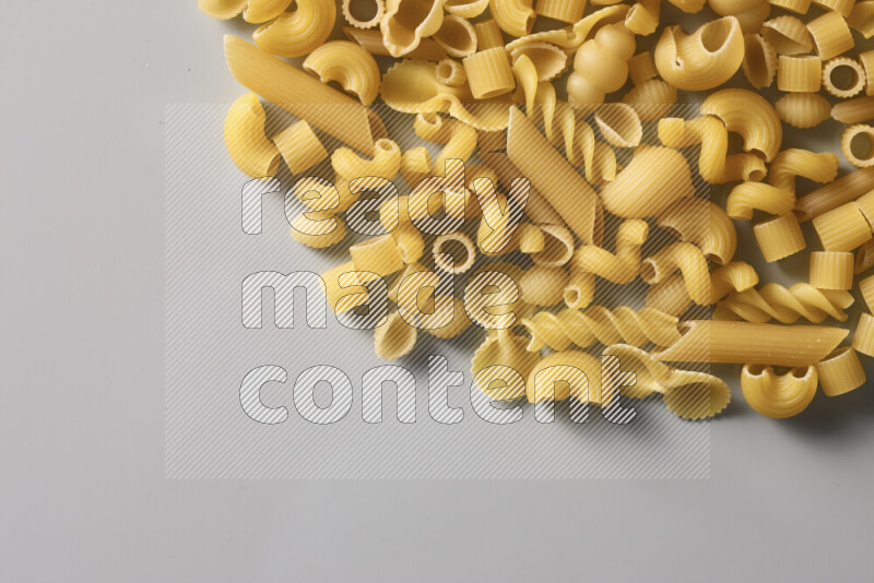 Different pasta types on light blue background