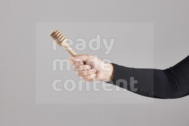 A woman in black abaya holding different wooden essentials in different positions