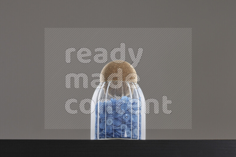 Buttons in a glass jar on black background