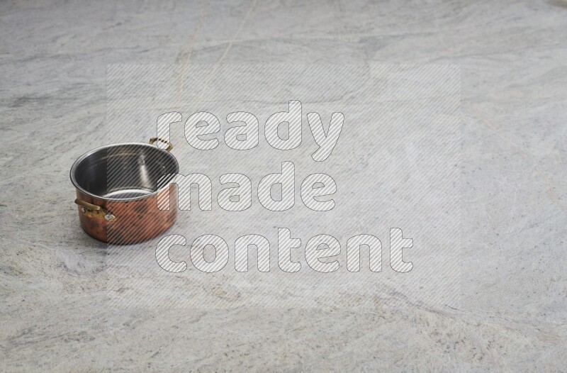 A small copper pot on grey marble background