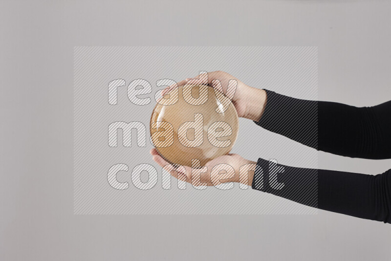A woman in black abaya holding different pottery essentials in different positions