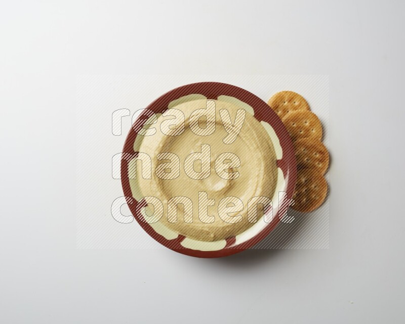 Plain hummus in a traditional plate on a white background
