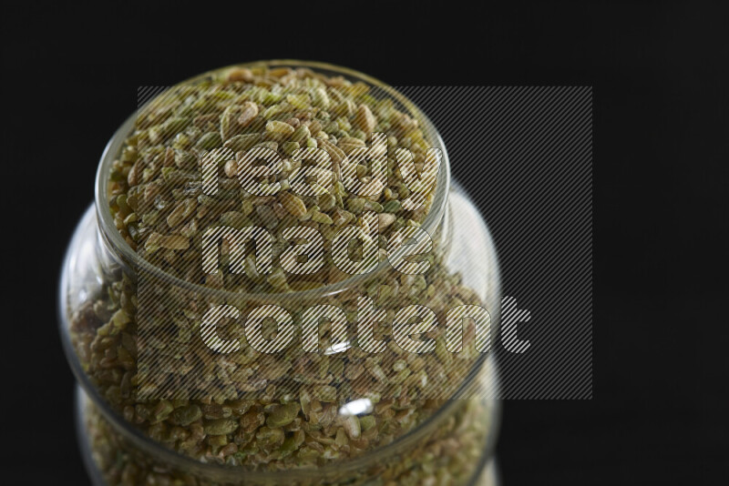 Freekeh in a glass jar on black background