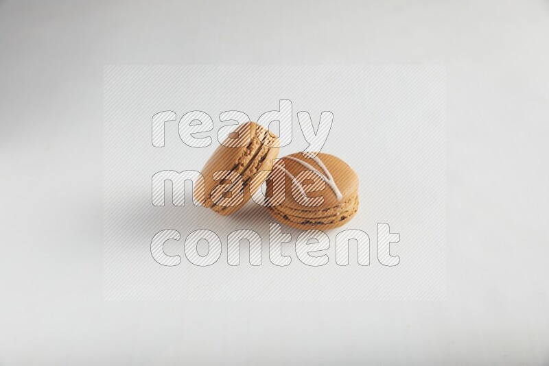 45º Shot of of two assorted Brown Irish Cream, and Brown Maple Taffy macarons  on white background