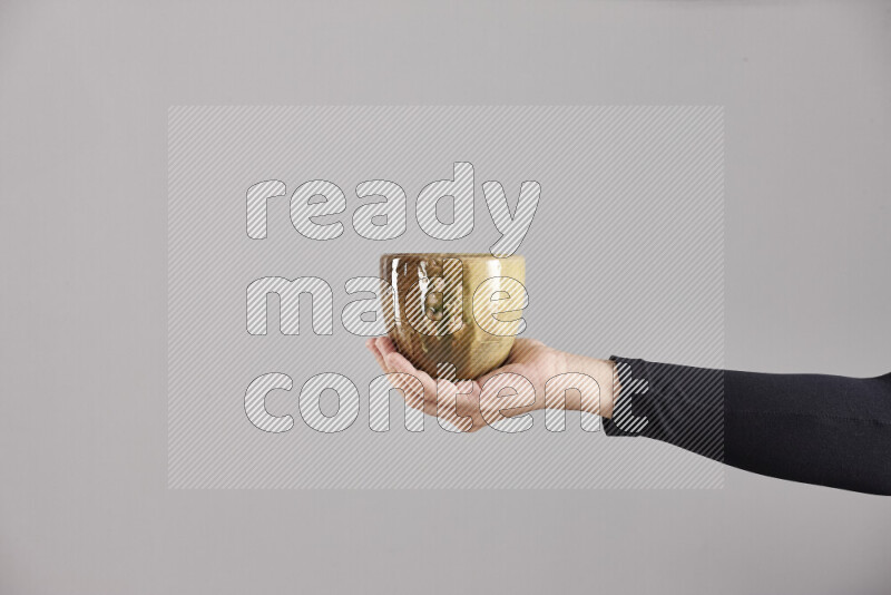 A woman in black abaya holding different pottery essentials in different positions