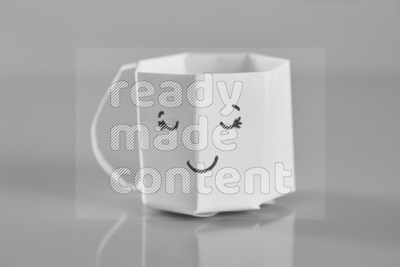 Origami cup on grey background