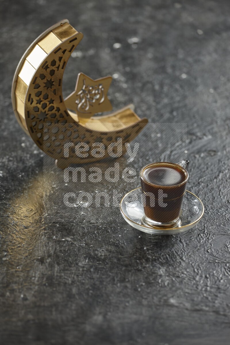 A wooden golden crescent lantern with different drinks, dates, nuts, prayer beads and quran on textured black background