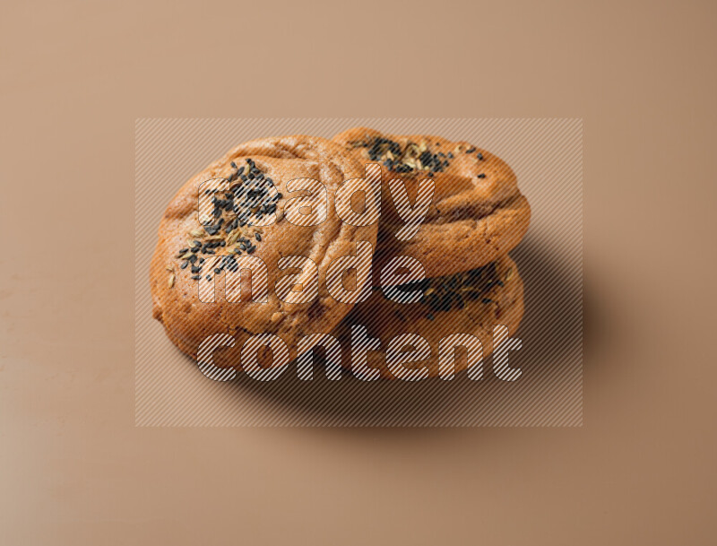 Hasawi cookies field with date and decorated by black seed and Anise grain on a brown background