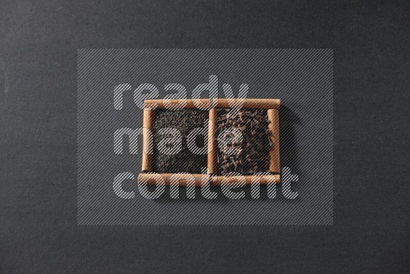 مربعان من أعواد القرفة ممتلئان بالشاي وحبوب القرنفل علي خلفية سوداء